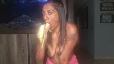 Jouer Desi seins nus serre ses seins pendant qu'elle suce et suce profondément une banane